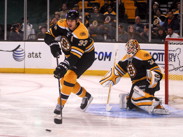 Bruins players, Zdeno Chara and goalie Tim Thomas in the defensive zone