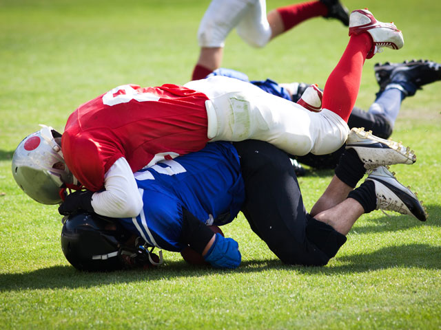 One football player tackling another