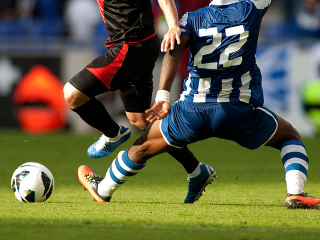 Two soccer players going after the ball